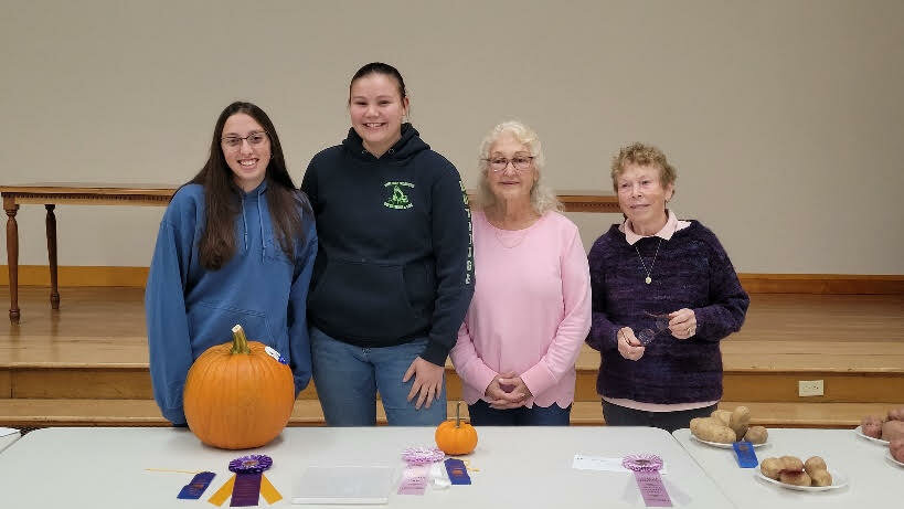 Nicole Non  is pictured at left with her 19-pound Grand Champion pumpkin. Channing Rutledge, second from left, shows her miniature Reserve Grand Champion pumpkin. With them are Wayne County master gardeners Wanda Eisenhauer, third from left, and Mary Fenton.